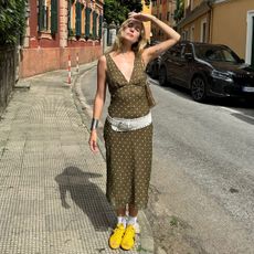 Woman in polka-dot dress and yellow sneakers