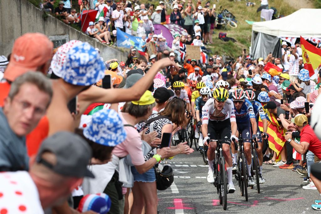 The pack of riders (peloton) cycles in the final ascent of Saint-Lary-Soulan Pla d'Adet during the 14th stage of the 111th edition of the Tour de France cycling race, 151,9 km between Pau and Saint-Lary-Soulan Pla d'Adet, in the Pyrenees mountains in southwestern France, on July 13, 2024. (Photo by Anne-Christine POUJOULAT / AFP)