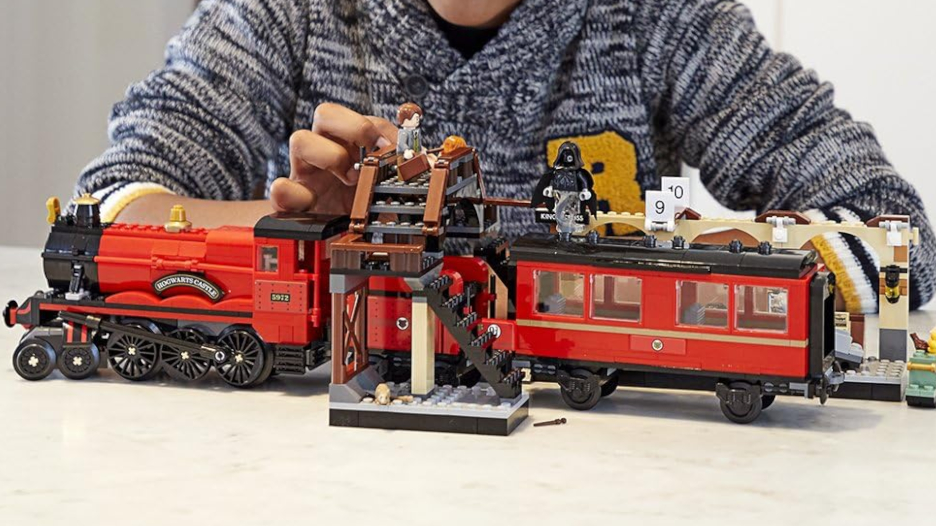 Lego Hogwarts Express, King's Cross Station, and minifigures being played with on a white surface