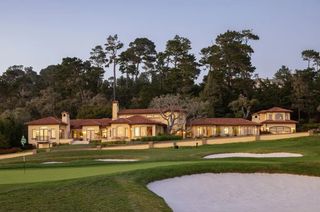 A house by a golf green and tee