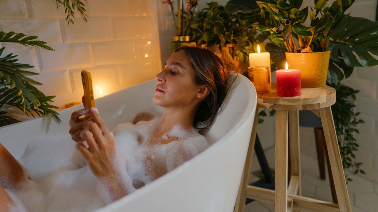 Best self care apps: A woman using a self care app on her phone