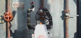 This image is a screengrab from a video showing Jet Propulsion Laboratory's RoboSimian turning a wheel at the DARPA Robotics Challenge in December 2013.