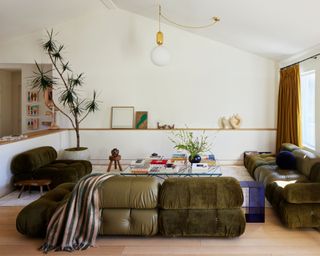 modern white living space with dark olive green vintage-inspired sofas