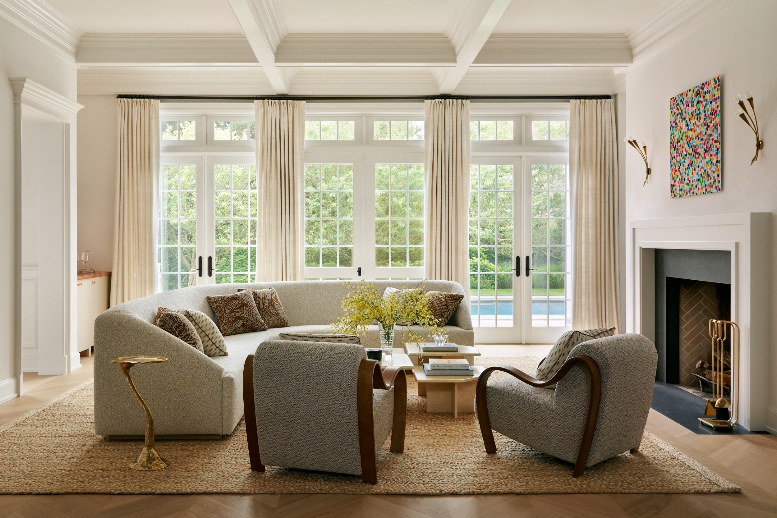 A curved sofa in a contemporary living room with two sculptural armchairs