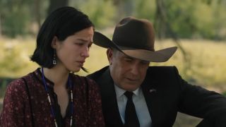 Monica and John sitting togehter at a funeral.