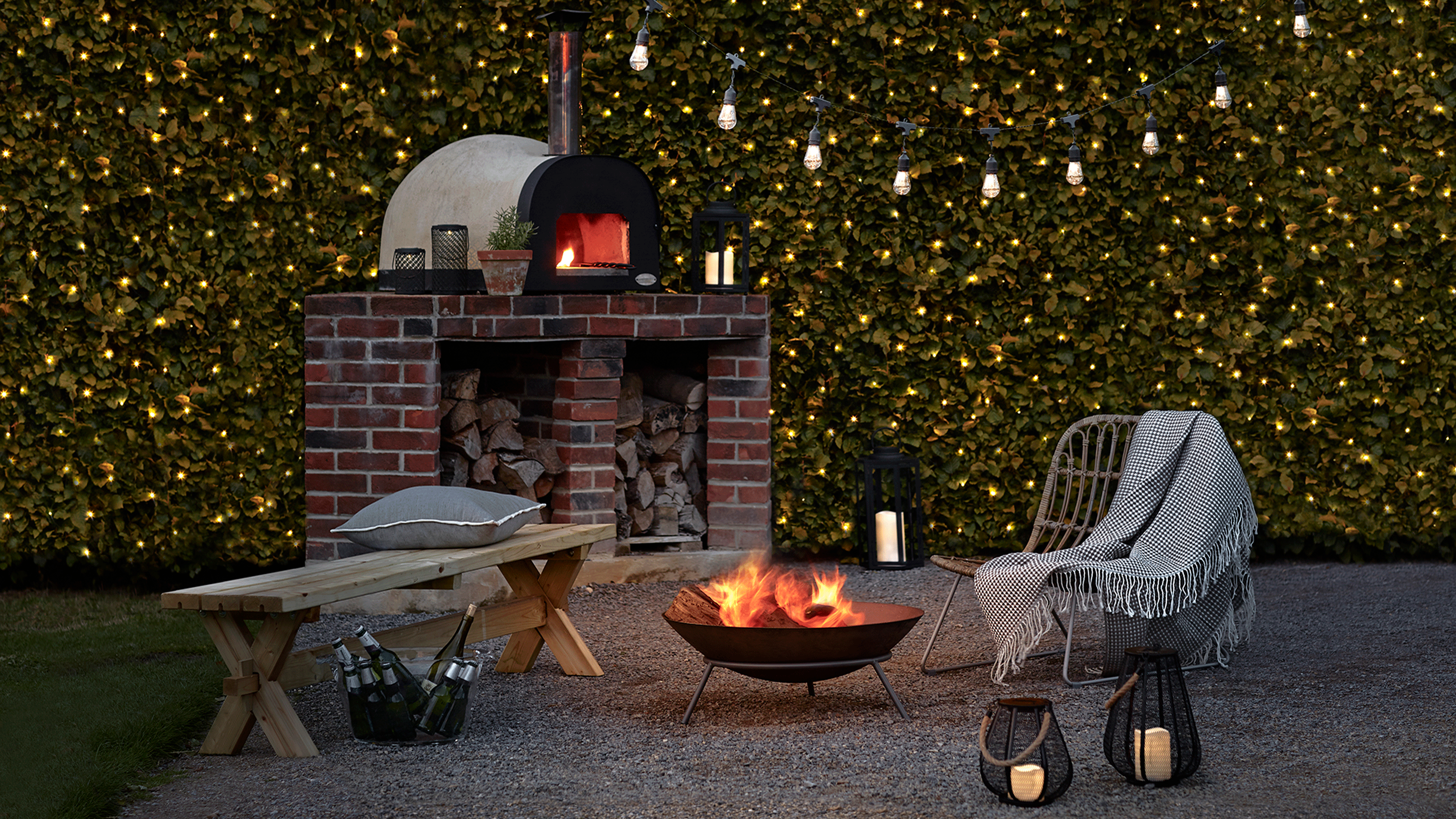 outdoor string lights and lanterns with fire pit and chairs