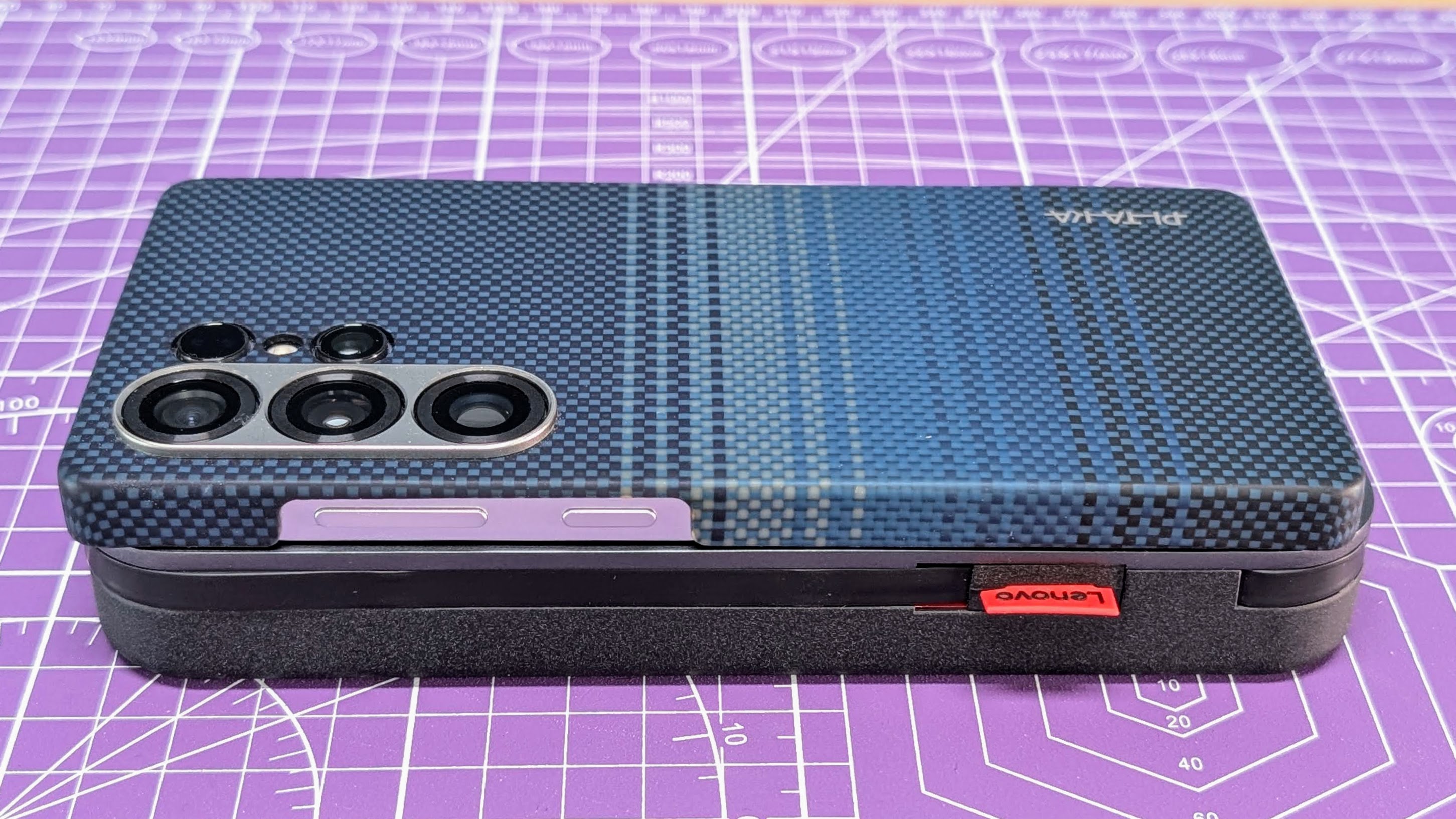 Lenovo Go USB-C laptop power bank with a Samsung Galaxy S25 Ultra smartphone sitting on top as a size comparison