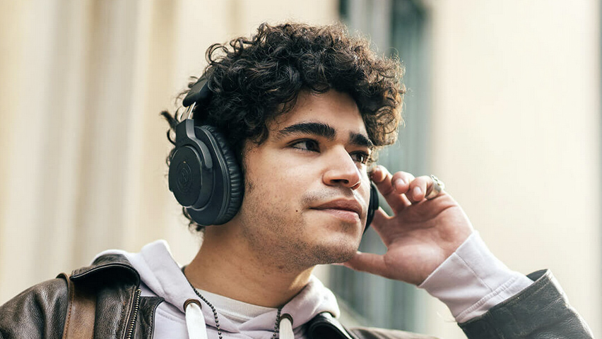 Man wearing Audio-Technica ATH-M20xBT Bluetooth wireless headphones.
