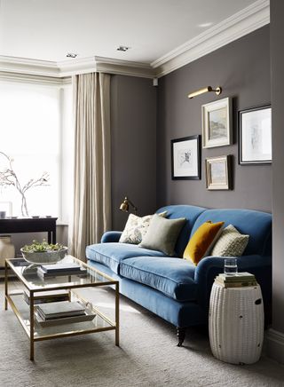 grey living room with blue velvet sofa and gallery wall by Sims Hilditch