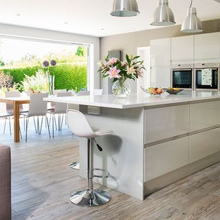white gloss kitchen with wood effect tiled floor