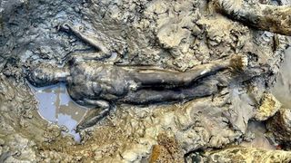 A mud-caked bronze sculpture unearthed in Italy. 