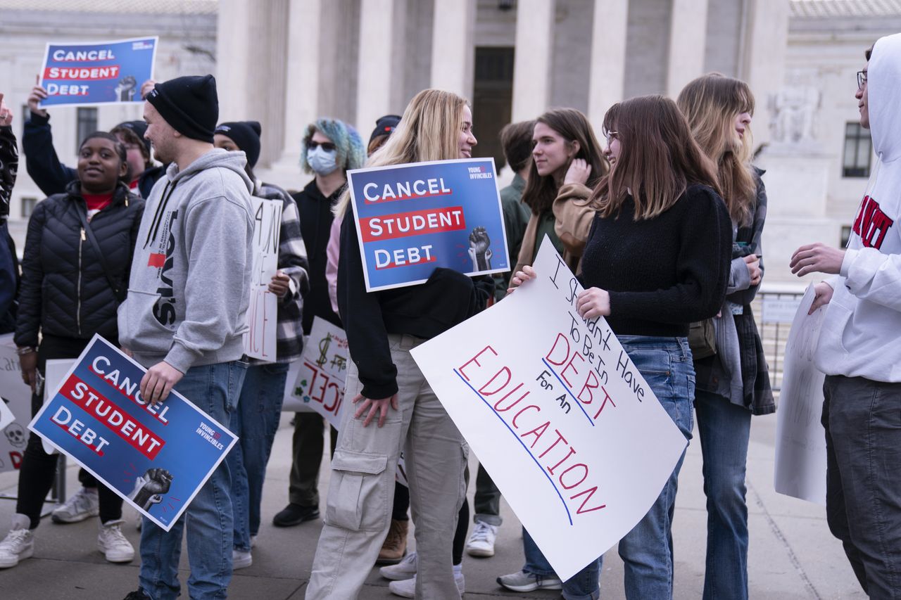 People with signs supporting student loan forgiveness