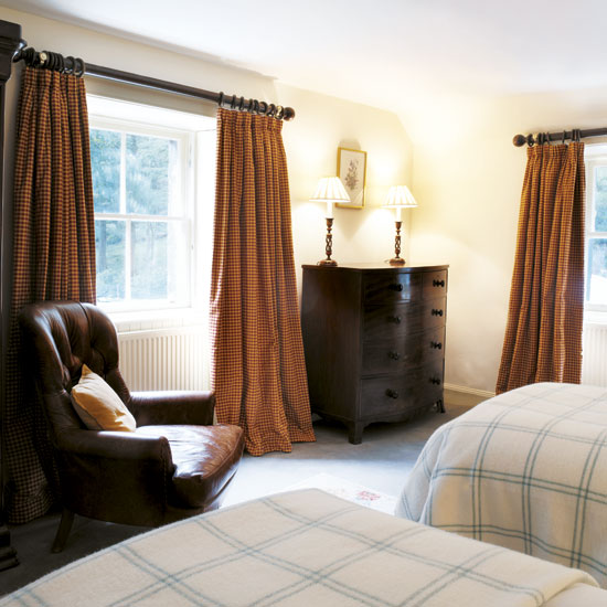 bedroom with white wall white window with curtains brown chair
