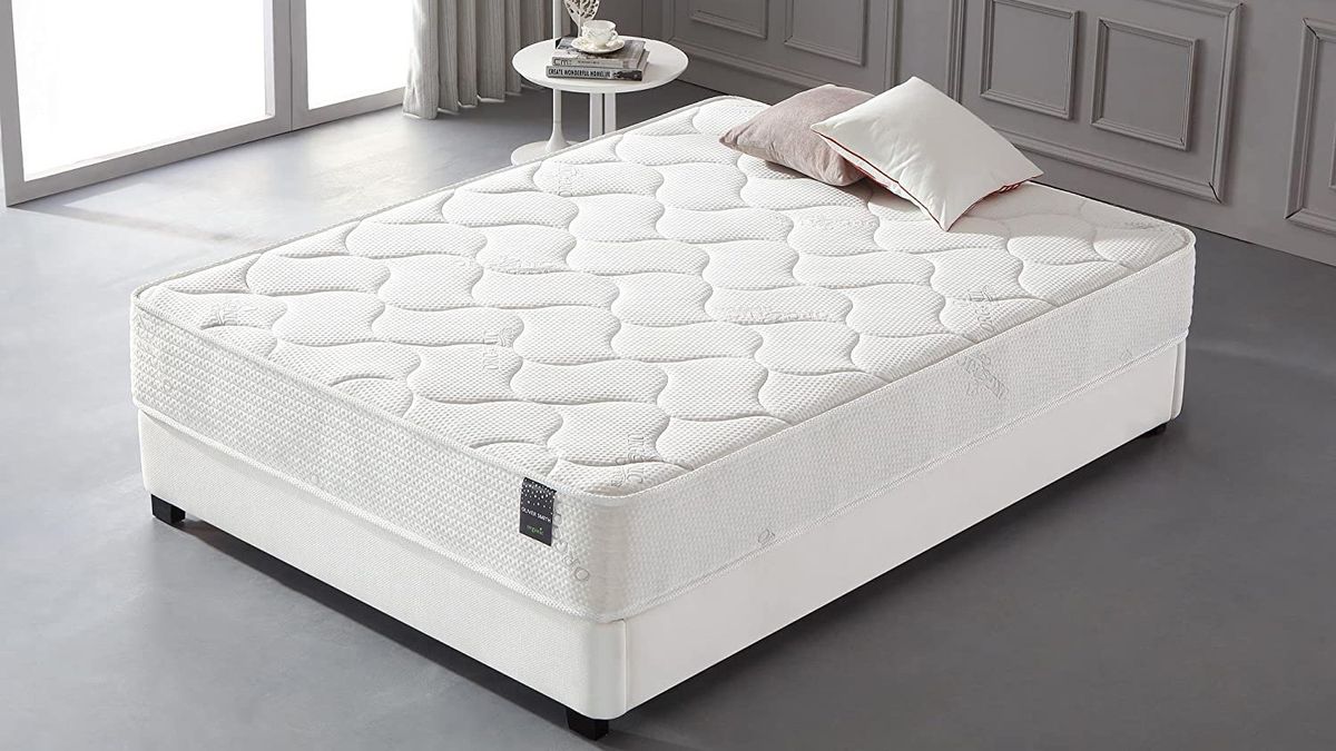 The Smith and Oliver Hybrid Mattress placed on a white bed base in a stylish grey bedroom