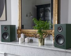 Spotify vs Apple Music Triangle speakers shown on top of a fireplace mantel