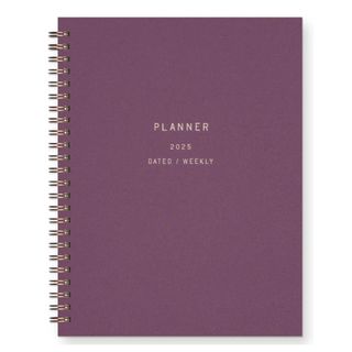 A purple planner with gold ring binding and text