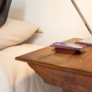 iOttie iON wireless mini fast charging pad in ruby on nightstand table