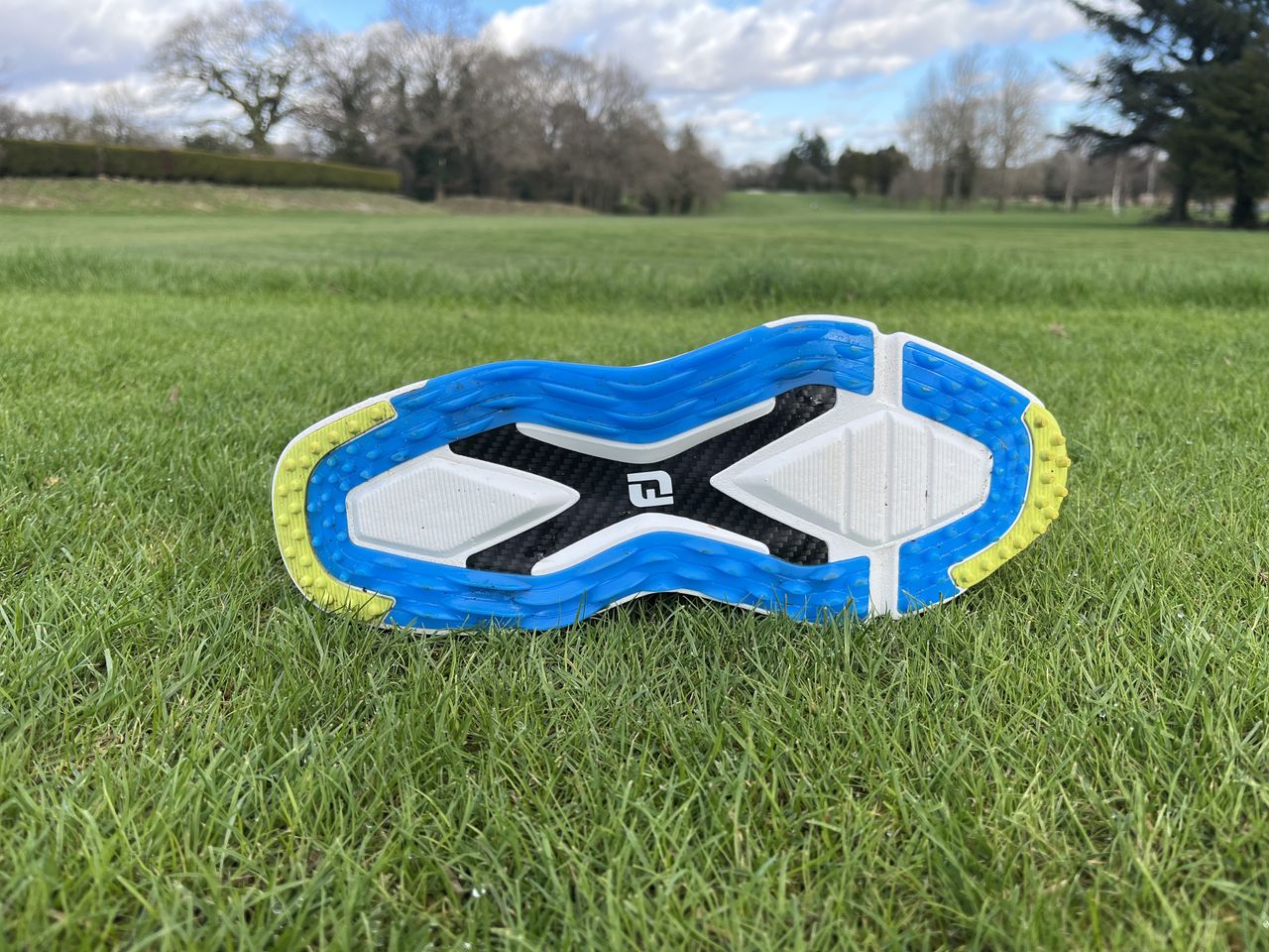 The outsole of the new FootJoy Pro/SLX Carbon golf shoe on grass