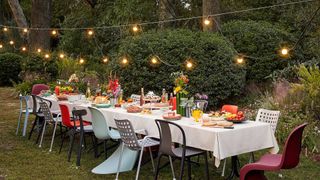garden party dining table with festoon lights suspended overhead