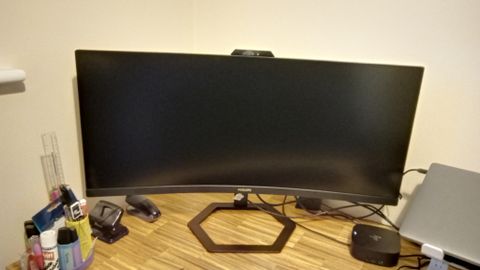 A black Philips 34E1C5600HE monitor on a wooden desk
