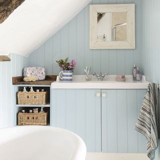blue bathroom with cabinet and flowers