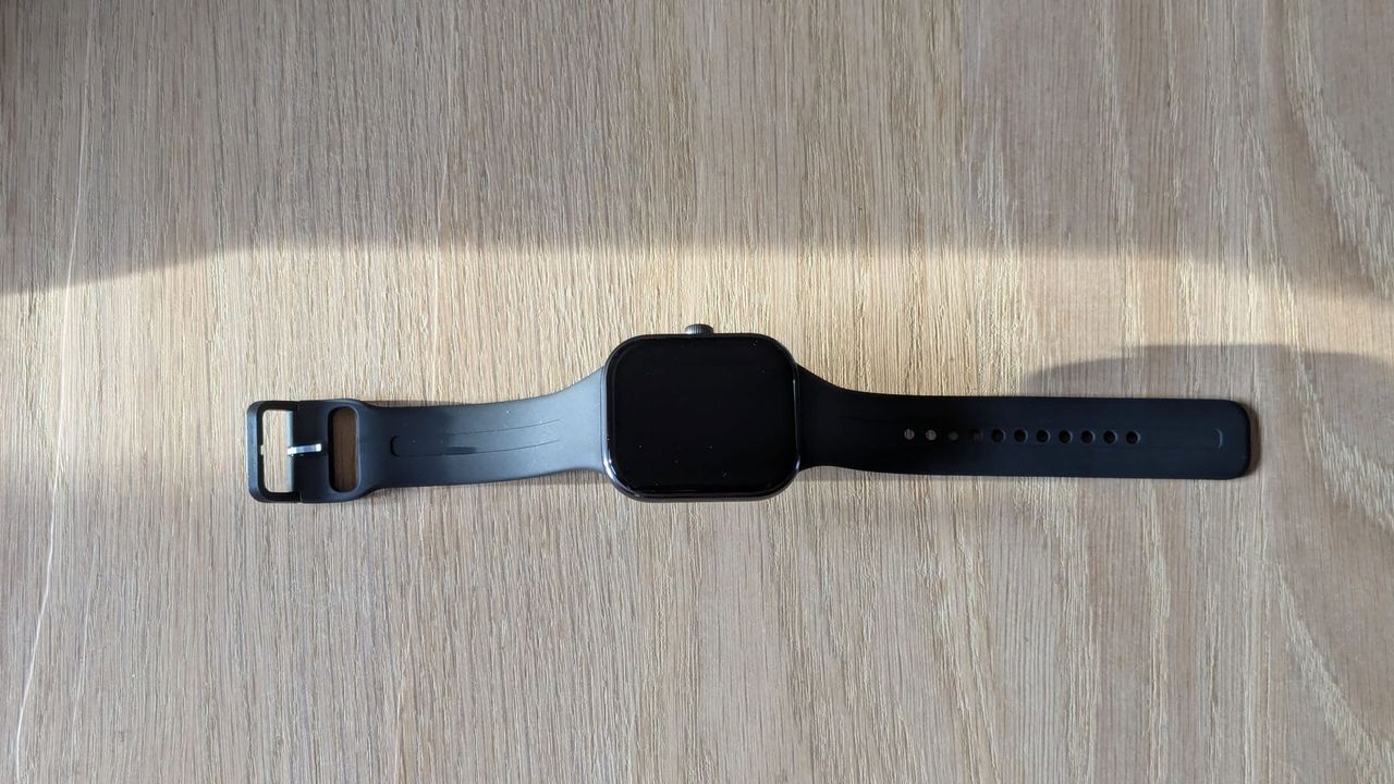 The Redmi Watch 5 laid flat on a wooden table.