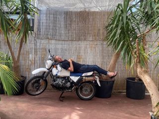 Tom Dixon snapshot of the designer lying on a motorbike in Goa