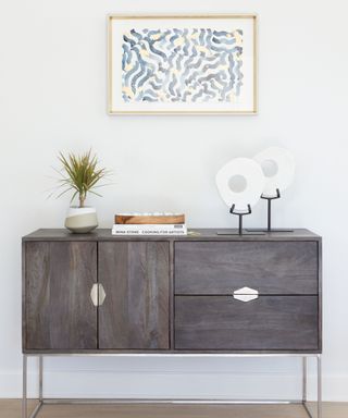 A coastal entryway with a console table and a piece of blue and white artwork