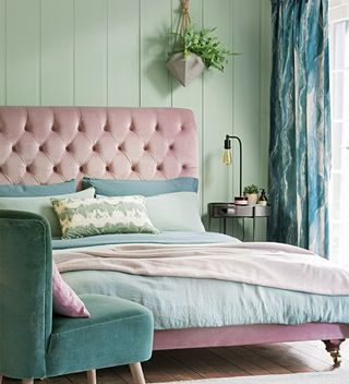 Bedroom with green panelled walls and pink velvet upholstered headboard