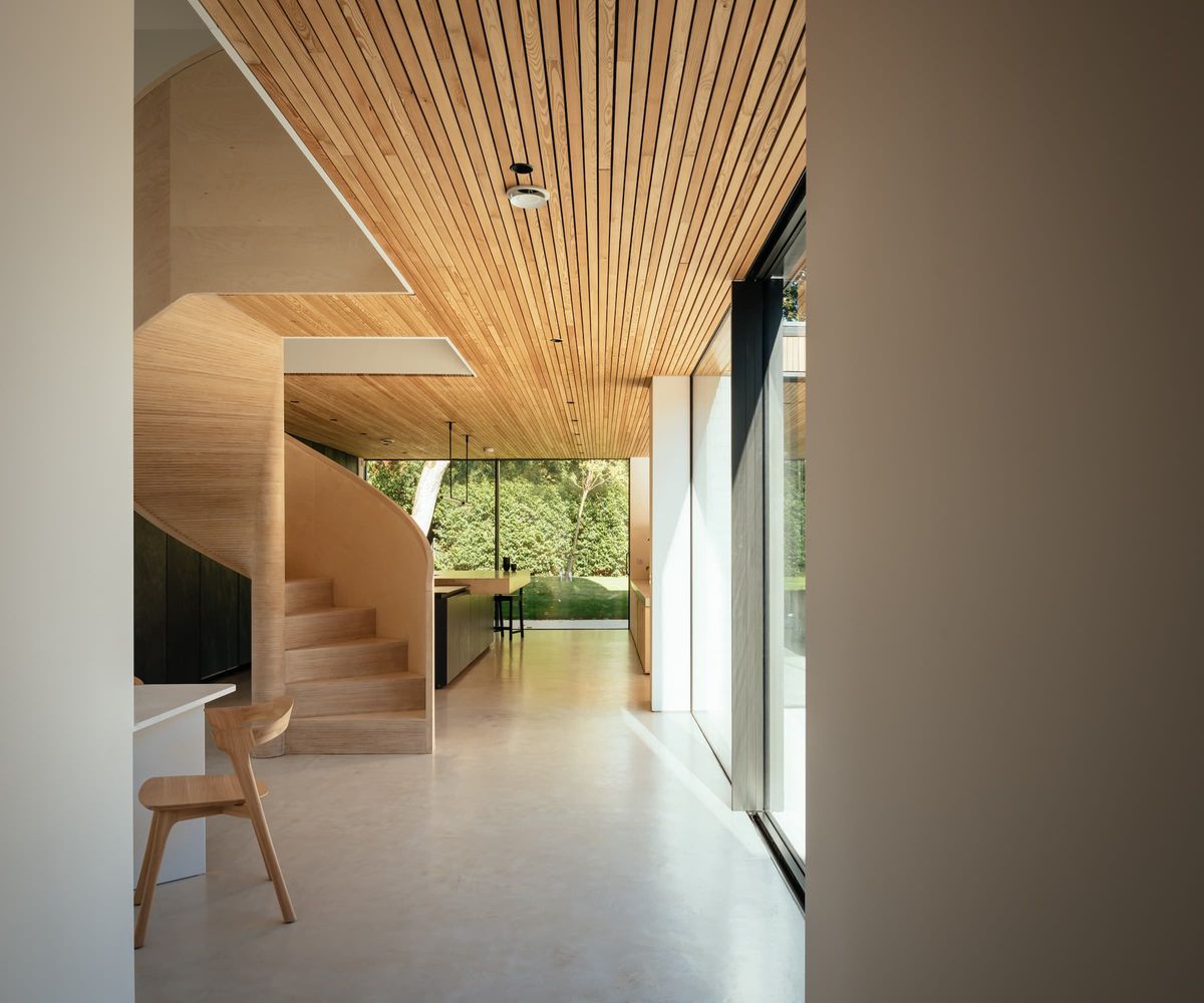 A wooden staircase with wooden clad ceilings on the bottom floor of a house