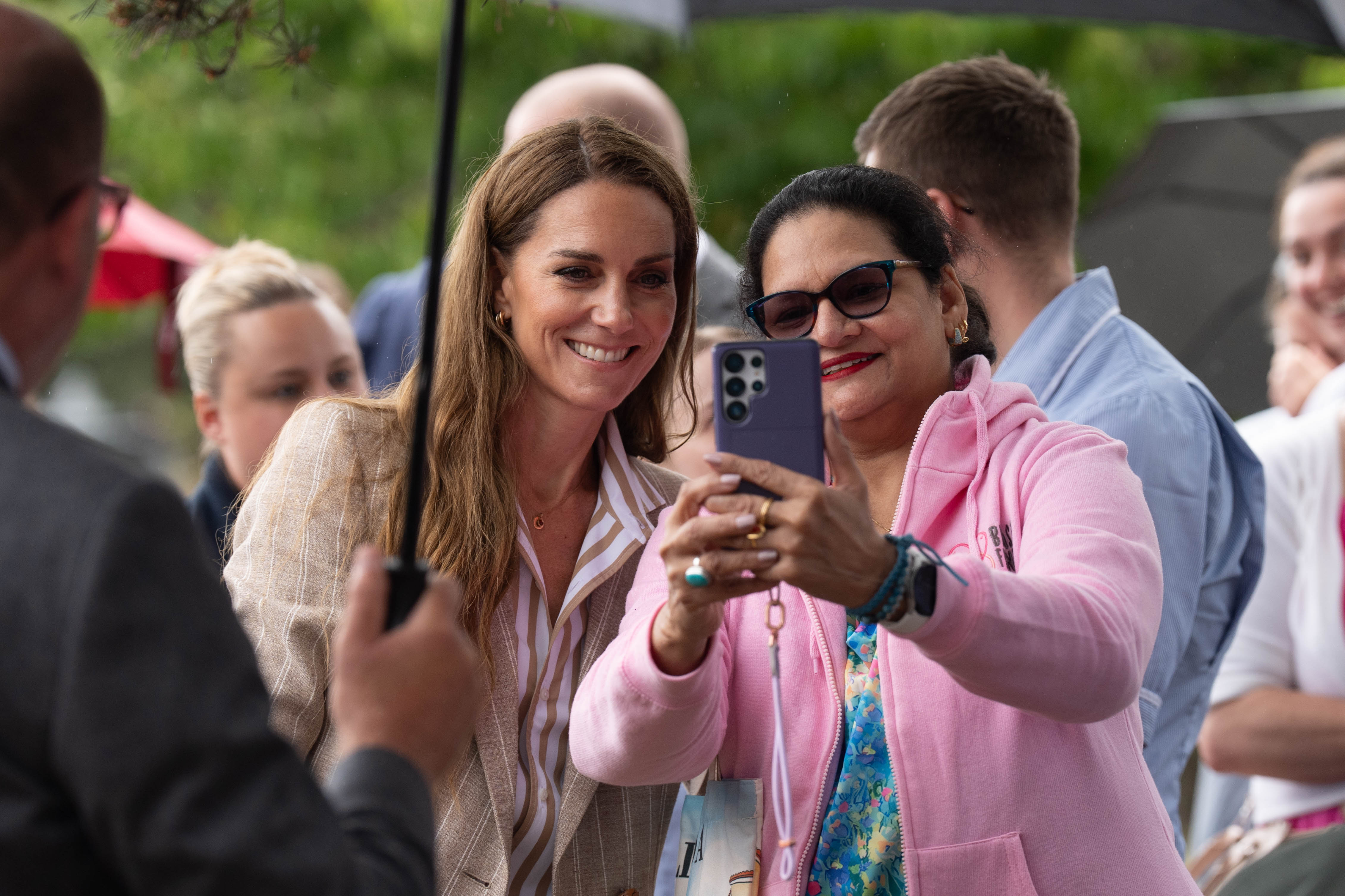 Kate Middleton taking a selfie with a woman in a pink hoodie