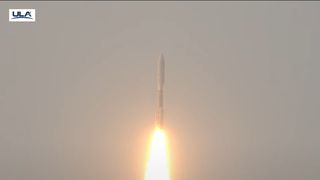 a rocket blasts off against a hazy sky
