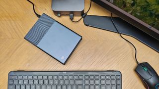 Photos of a silver grey HD box on a wooden desk