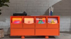 A bright orange record bar with a record player and a trio of candles