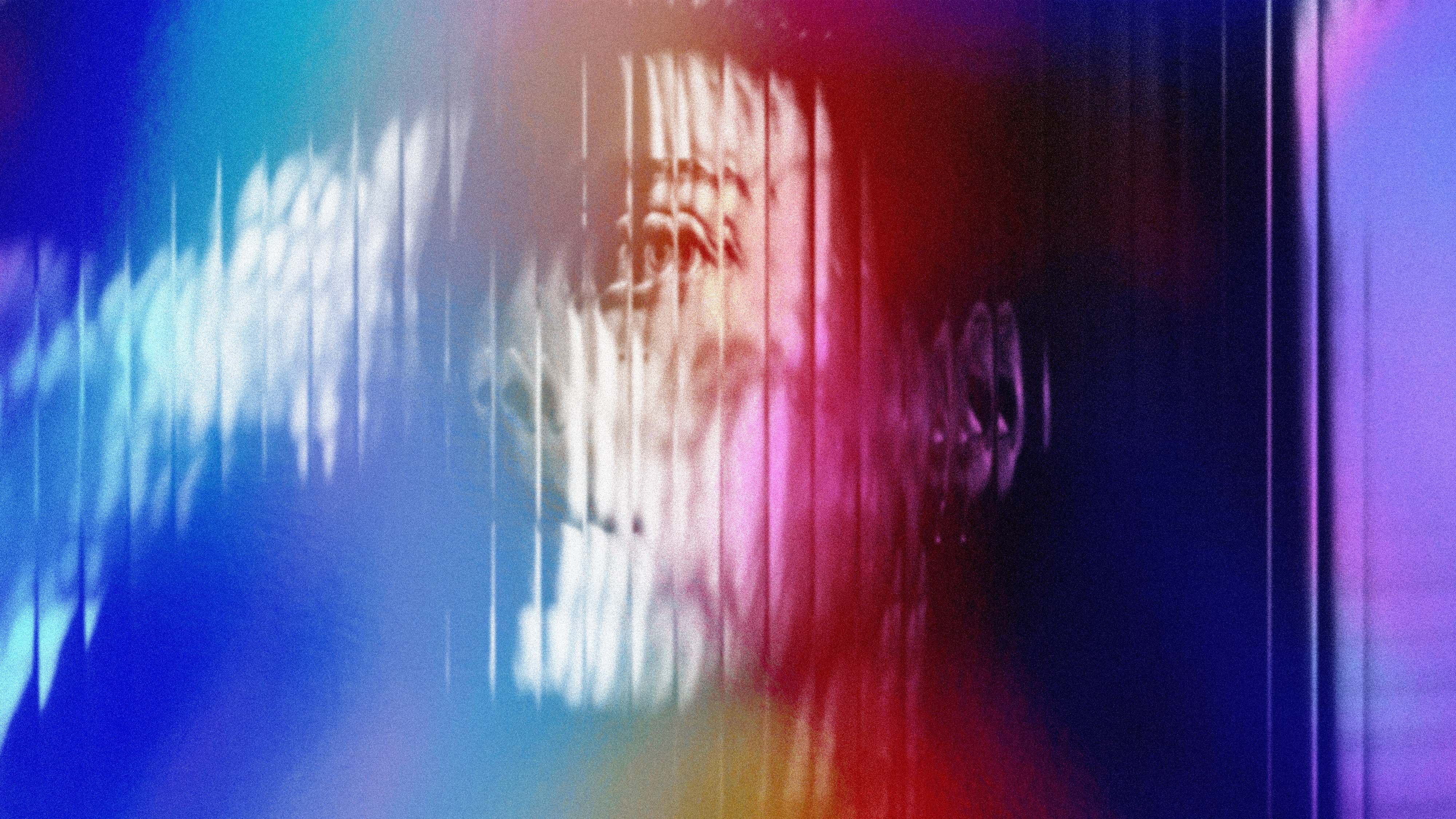 image of a woman&#039;s face behind a rainbow mirror