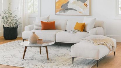 Labor Day furniture sale with Article MARA coffee table in living room on rug by white sofa with throw cushions