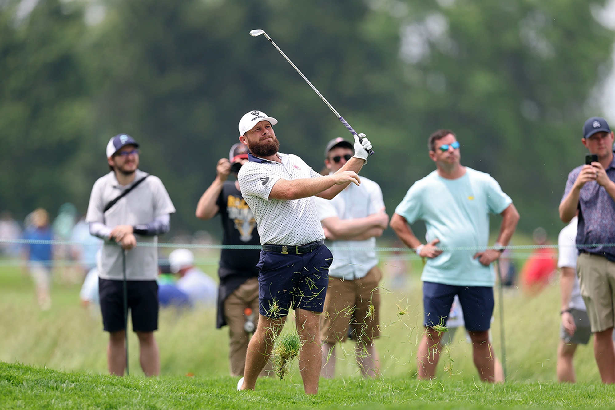 Tyrrell Hatton hitting a shot out of long rough down the left side of the 1st hole at Oakmont during the US Open