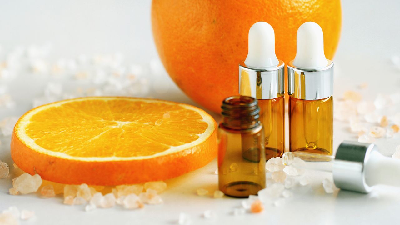 sliced orange with skincare bottles