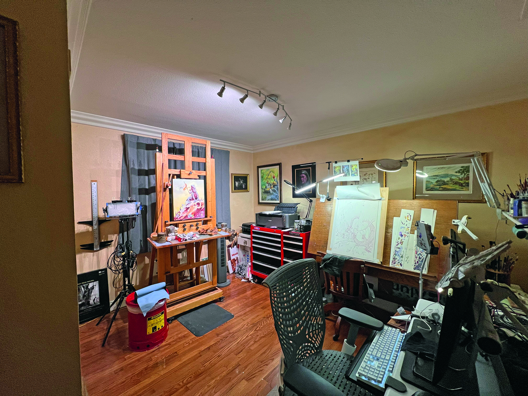An artist studio with a large wooden easel and desktop computer
