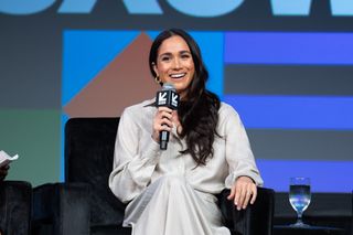 Meghan Markle smiles onstage at SXSW wearing a cream set