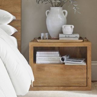 Cayman Nightstand against a gray wall.