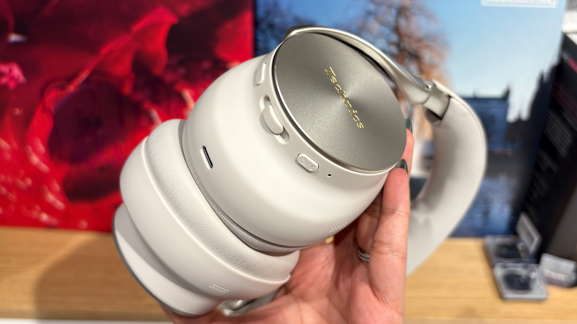 Technics EAH-A1000 wireless over-ear headphones held in hand with ear cups together