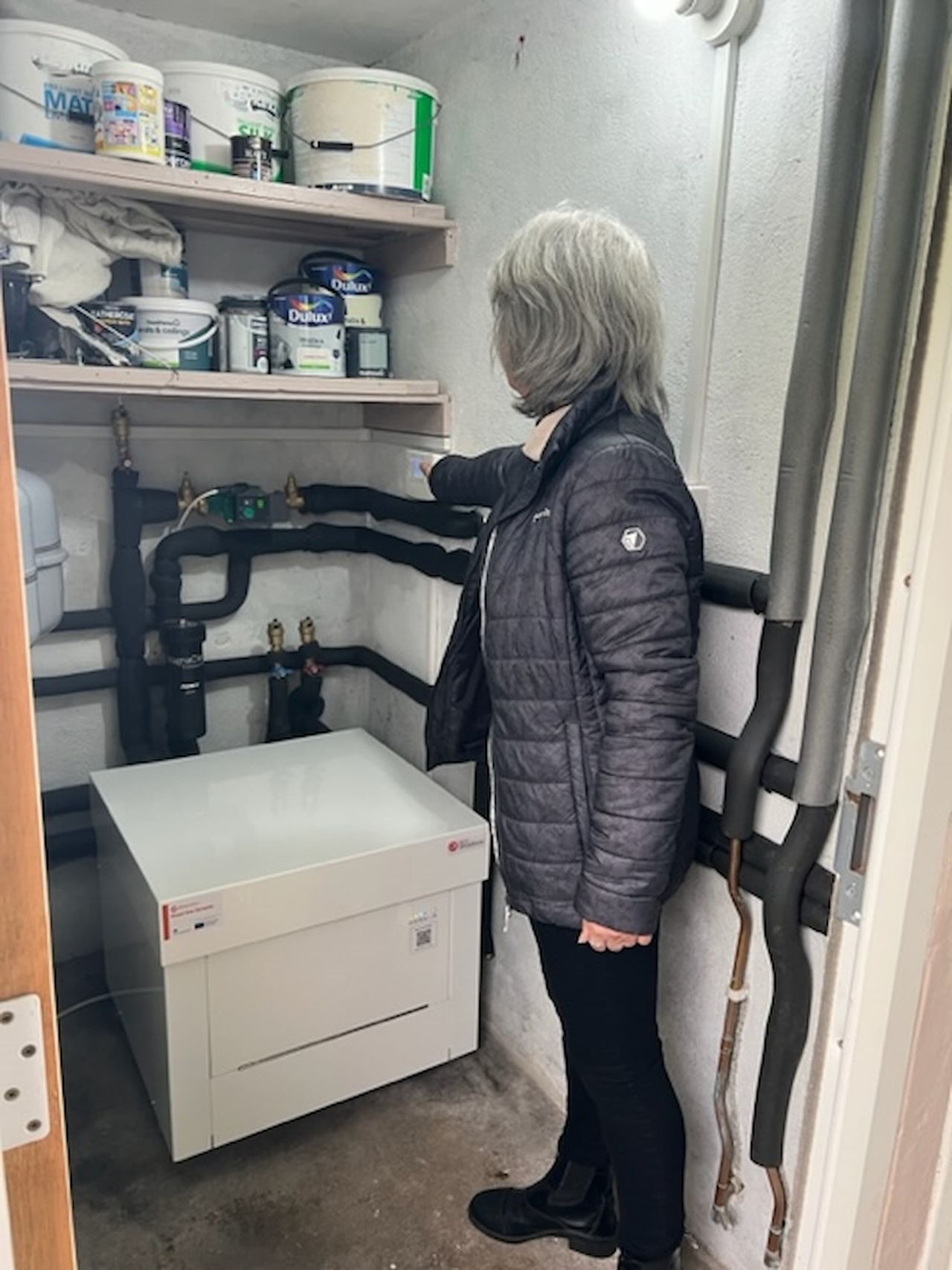 Grandmother stood in front of new ground source heat pump