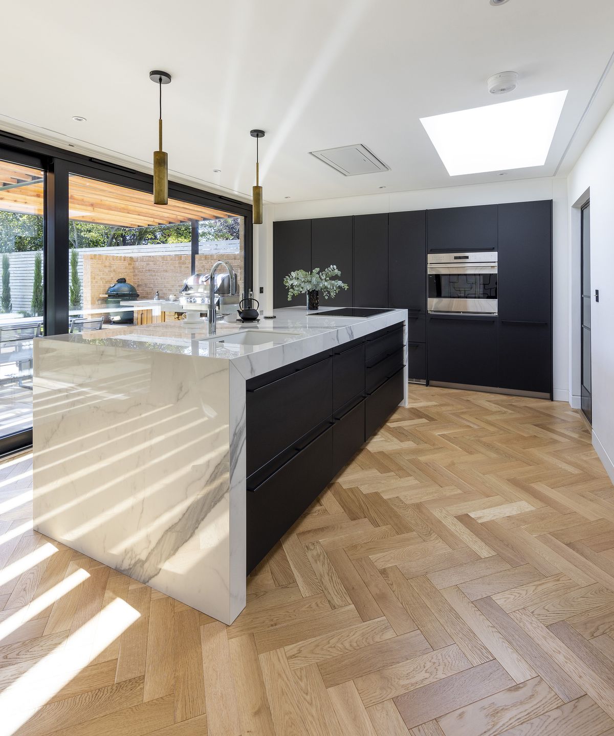 a contemporary kitchen with dark cabinets and a rectangular kitchen island