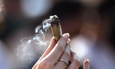 A woman holds a joint at a 2010 pro-marijuana &amp;#039;4/20&amp;#039; celebration in front of the state capitol building in Colorado.