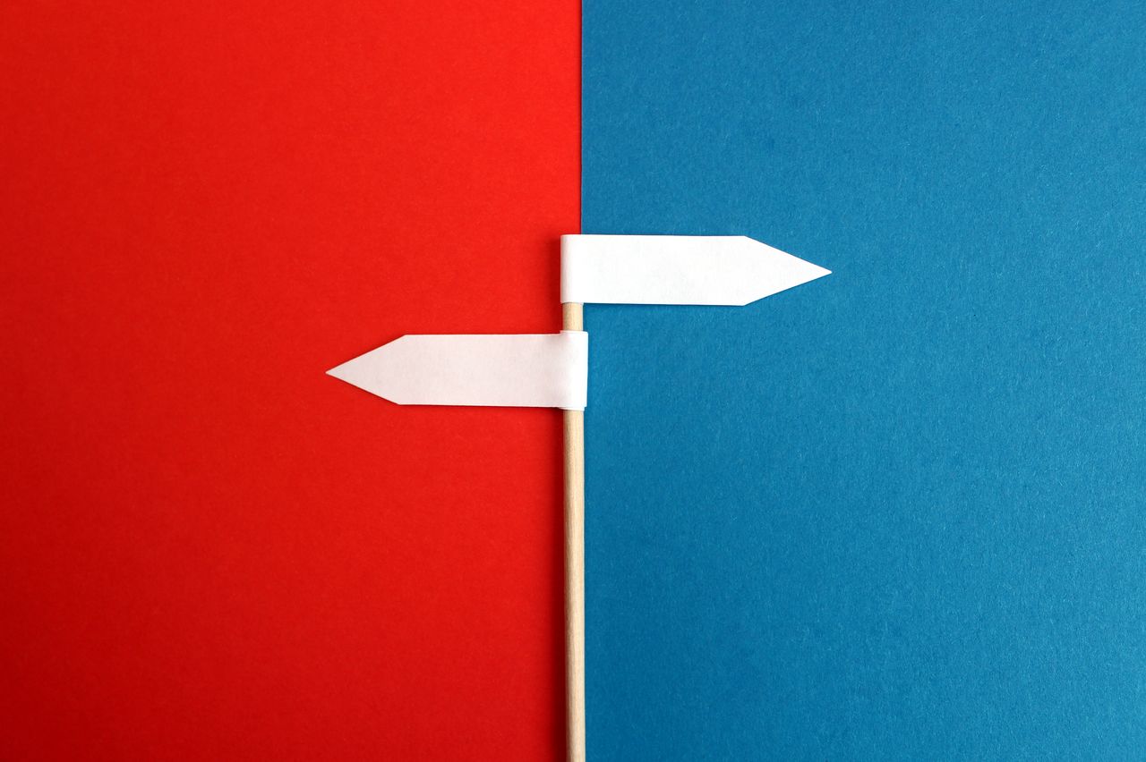 white flags pointing opposite directions on split red and blue background