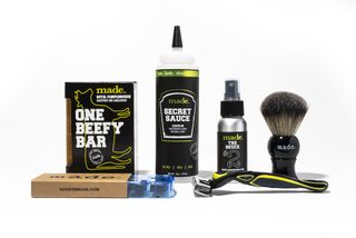 A line up of Made products including One Beefy Bar, Secret Sauce, a razor, a shaving brush and The Deuce spray