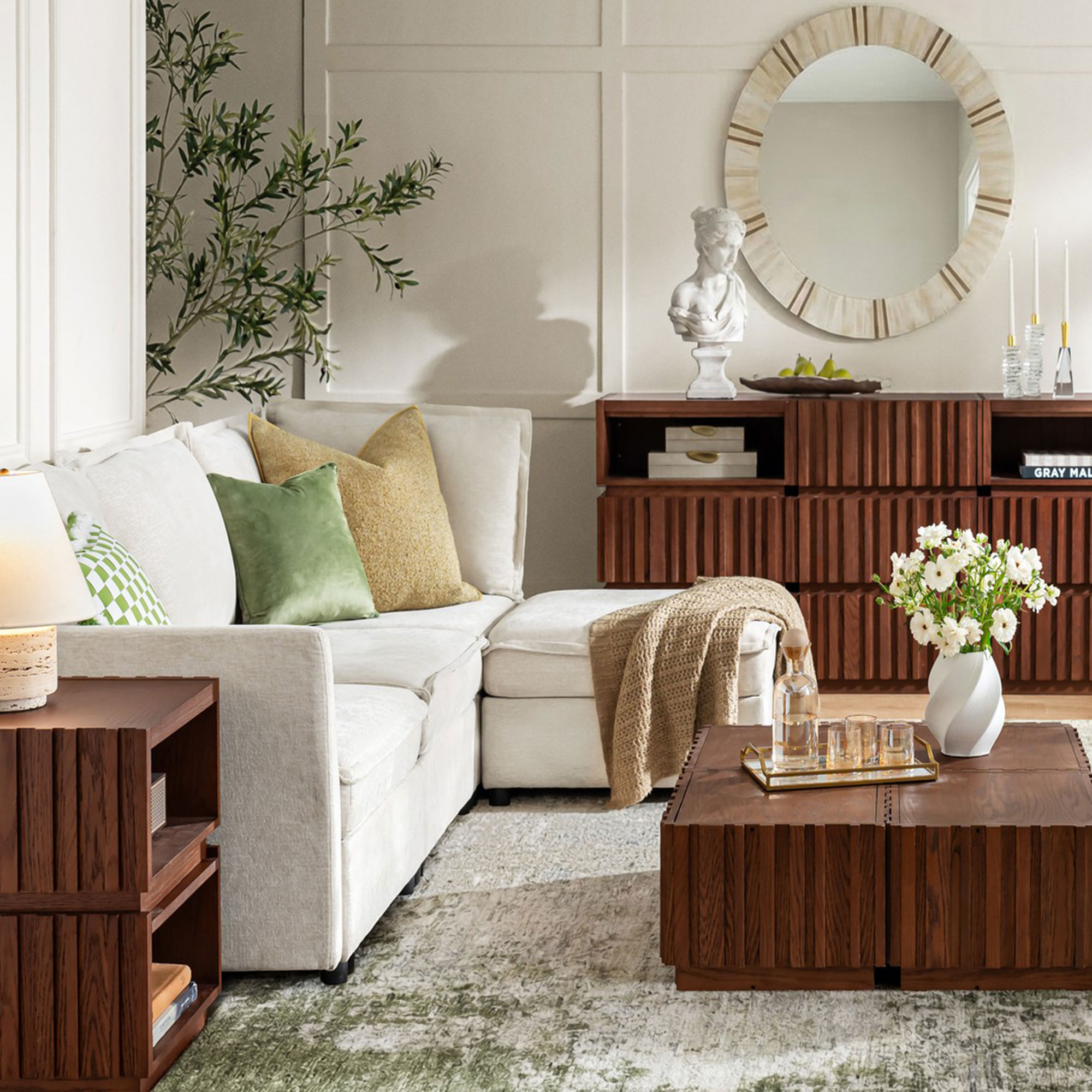 White living room with brown wooden sideboard, coffee table and side table on rug by white sofs