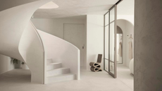 an all white curving staircase in a white washed room