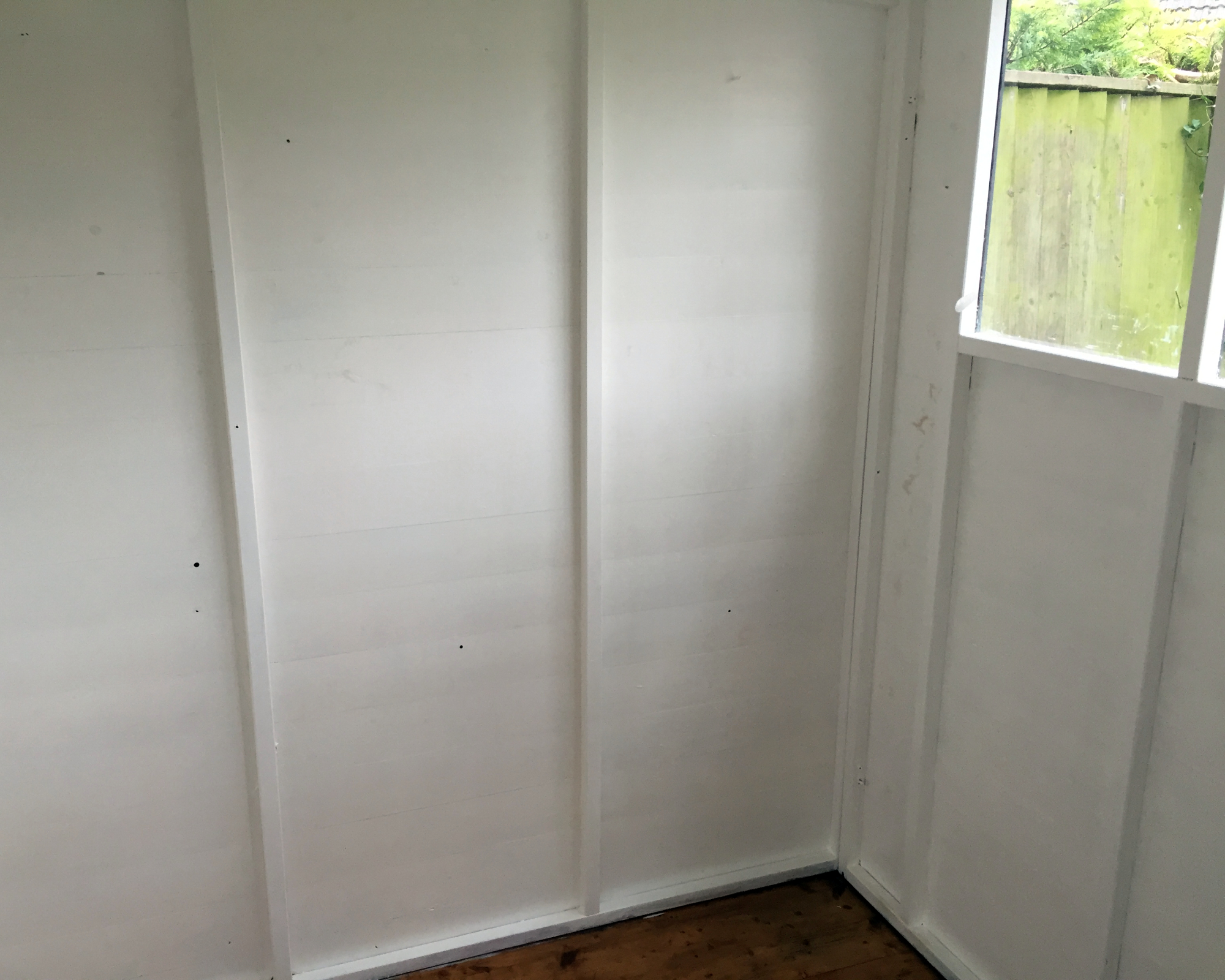 Interior of wooden shed painted white